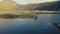 Cinematic drone flight over fishery farm cages and small huts in the lake.