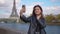 Cinematic footage of a young woman wearing fashionable clothes having fun in Paris at the eiffel tower park and streets