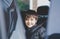 Cinematic portrait boy siting in safety car seat looking at camera with smiling face,Child sitting in the back passenger seat with