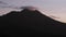 Cinematic shot of cloudy sunrise with Batur volcano silhouette in Bali