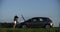 CINEMATIC SHOT two women in shorts and a t-shirt stand open hood of the car on the road