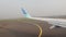 Cinematic Shot of A Wing Commercial Aircraft Trails on Airport Runway in Foggy Morning