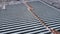 Cinematic top down aerial view on graphic straight lines of solar power panels in snowy field in winter