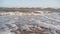 Cinematic white foamy waves crashing on the sandy shore. Amazing seascape of water surface texture. Sand is washed by