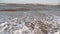 Cinematic white foamy waves crashing on the sandy shore. Amazing seascape of water surface texture. Sand is washed by