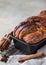 Cinnamon babka or swirl brioche bread on black metal grille. Cinnamon roll bread. European Easter sweet bread. Homemade pastry for