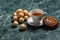 Cinnamon bun with saucer, black tea and cookie walnut on marble background