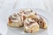 Cinnamon buns on elegant plate white wood background