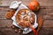 Cinnamon cinnamon rolls buns with pumpkin, nut, caramel and sugar cream iced on rustic wooden background table. Top view. Sweet Ho