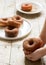 Cinnamon donuts in children`s hands and on a wooden table