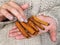 Cinnamon pods in the hands of a girl. A woman in a knitted wool sweater holds cinnamon in her hands. Cozy atmosphere