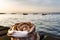 Cinnamon roll on a wooden boardwalk by the ocean at dusk with the Oresund Bridge. Cosy Swedish fika wit bun by the sea at sunset