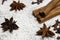 Cinnamon sticks and anise stars closeup on powdered sugar table. Cooking and baking background. Aromatic condiment and spices.