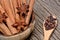 Cinnamon sticks with star anise in a bowl and cloves in a wooden spoon