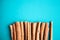 Cinnamon sticks on the turquois background, flat lay