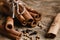 Cinnamon sticks on wood table with bundles of cinnamon, coriander, cloves, in soft focus in wooden background, macro vintage