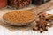 Cinnamon in a wooden spoon on old wooden table.