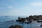 Cinque Terre, Italy - rugged beach near Riomaggiore, a seaside town in the Italian Riviera. Boat in the distance. Summer travel