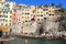 Cinque Terre village Riomaggiore with colorful houses and people bathing