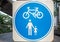 Circle blue and white road sign on white square steel plate for pedestrian and bicycle zone