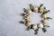 Circle border for easter card or invitation. Easter wreath with easter quail and leaf sprigs of eucalyptus. On a gray concrete bac