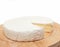 Circle Brie cheese on wooden desk isolated