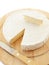 Circle Brie cheese on wooden desk with knife