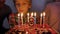 In the circle of a large family, the child extinguishes candles on the day of the eighth birthday.