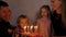 In the circle of a large family, the child extinguishes candles on the day of the eighth birthday.