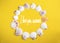 Circle of white seashells on yellow background with lattering