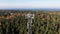 Circling above telecommunication tower with cellular antennas on forest and sea background