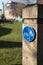 Circular blue shared cycle path sign for cyclists and pedestrians on a wooden post