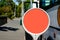 Circular bus stop sign template with orange background on a metal pole at footpath