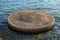 Circular concrete object surrounded by shallow sea