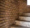 Circular concrete staircase with beige brick background. Stairs
