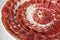 Circular decorative arrangement of iberian cured ham on plate
