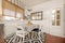 Circular dining table in the corner of a kitchen under a window