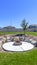 Circular fire pit surrounded by rocks in the middle of the grassy yard of a home