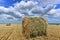 Circular haystack in windmill farm field with