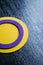 A circular intersex flag on a textured surface