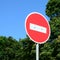 A circular red sign with a white bar indicating NO ENTRY on a grey metal post