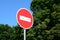 A circular red sign with a white bar indicating NO ENTRY on a grey metal post