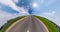 Circular rotation of the hemisphere of the earth on asphalt road among green field in blue sky. loop revolve