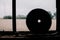 Circular saw blade positioned in front of a window overlooking a vast wheat field