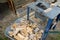 Circular saw with cut firewood in the background in a wheelbarrow