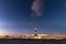 Circular star trails revolving around Polaris with a lighthouse beacon in the foreground. Fire Island lighthouse, NY