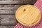 Circular wooden table and checkered cloth napkin.