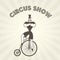 Circus actor on retro bicycle - strongman on old penny farthing