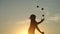 Circus artist juggling with balls on colorful sunset