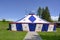 Circus tent, small circus tent in blue and white with red stars standing on green meadow.